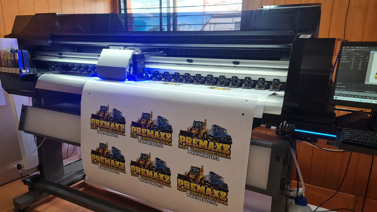 Plotter de impresión gran formato produciendo adhesivos corporativos en el taller de Plus Gráfica